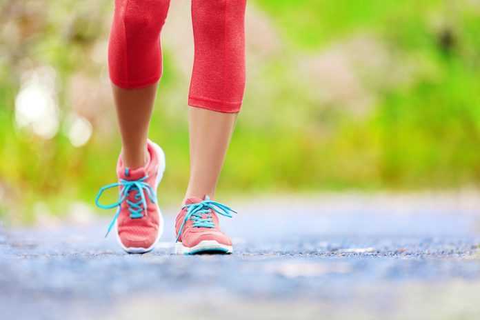 Jogging woman with athletic legs and running shoes. Female walki