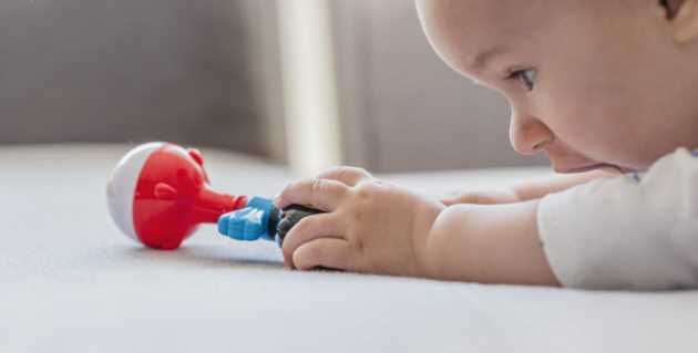 Baby with rattle in hand.