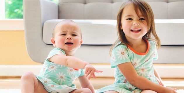 Toddler sisters fighting over a tablet computer in their living room